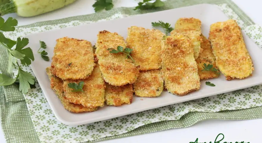 Cotolette di zucchine dorate e croccanti, guarnite con prezzemolo fresco. Un contorno sfizioso e leggero.
