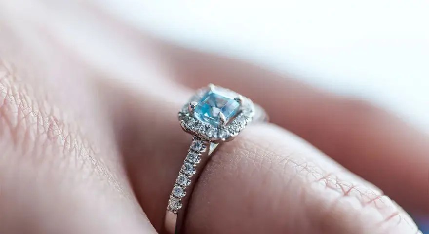 Anello con acquamarina centrale e diamanti, montatura in rodio o argento.