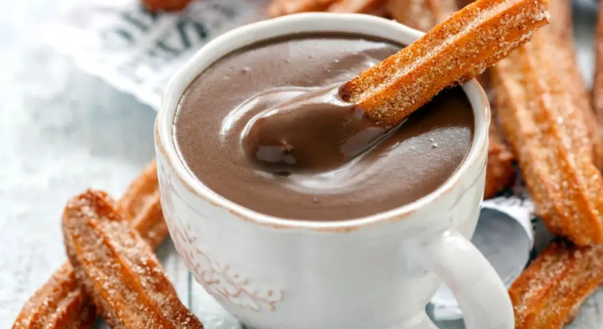 Ein Churro-Rezept zum Genießen: Knusprige Churros werden in heiße Schokolade getunkt.