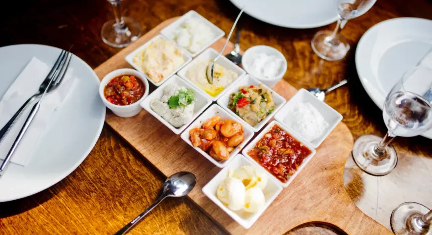 Meze-Platte mit verschiedenen Dips und Beilagen, wie Hummus und Salsa, serviert im Hasir Kreuzberg.