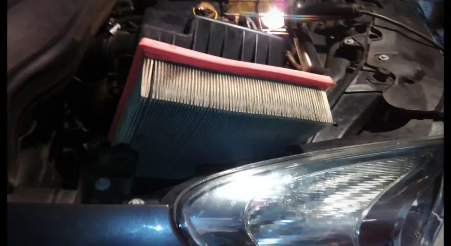 Wymiana filtra kabinowego Opel Corsa D. Nowy filtr czeka na montaż w komorze silnika.