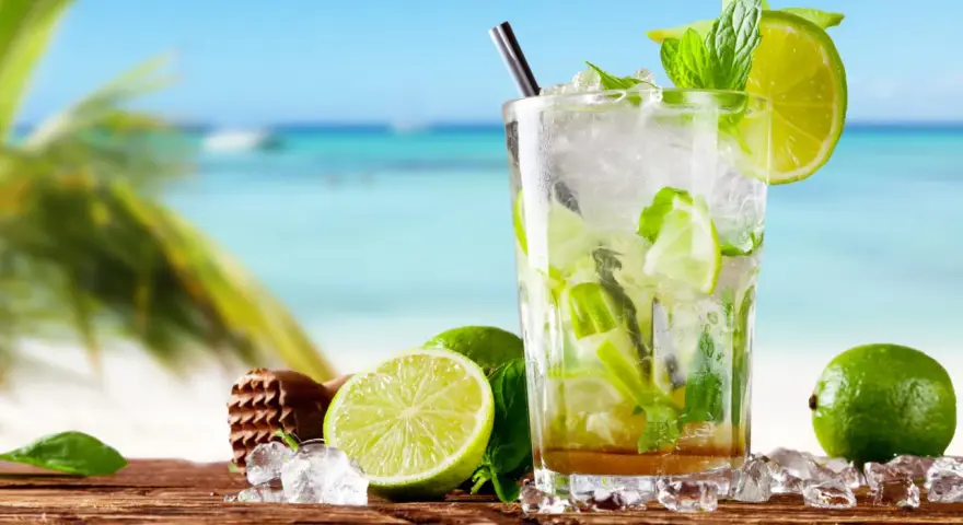 Orzeźwiający mohito drink co zamiast rumu? Idealny na plażę, z limonką i miętą, na drewnianym blacie, z widokiem na morze.