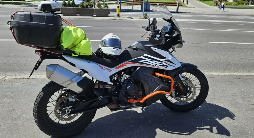 Motocykl KTM 790 Adventure gotowy na przygodę po NC500 Szkocja. Kask i jaskrawożółty pokrowiec na bagaż czekają na start.