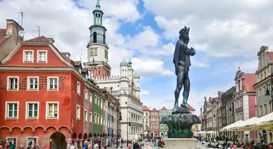 Rynek w Poznaniu z fontanną i kolorowymi kamienicami.