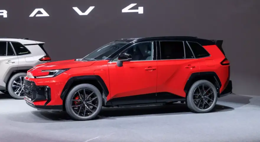 Czerwony, tani SUV z czarnym dachem i felgami, prezentowany na wystawie obok białego modelu.
