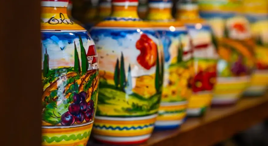 Kolorowe, ręcznie malowane butelki z motywami włoskiego krajobrazu. Idealne, by znaleźć gdzie kupić pamiątki w Rzymie.
