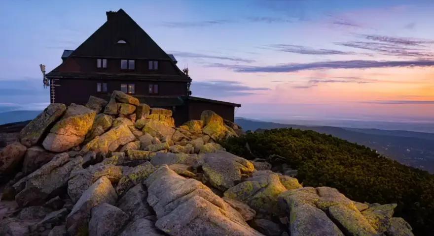 Schronisko na Szrenicy wśród skalnego krajobrazu o wschodzie słońca.