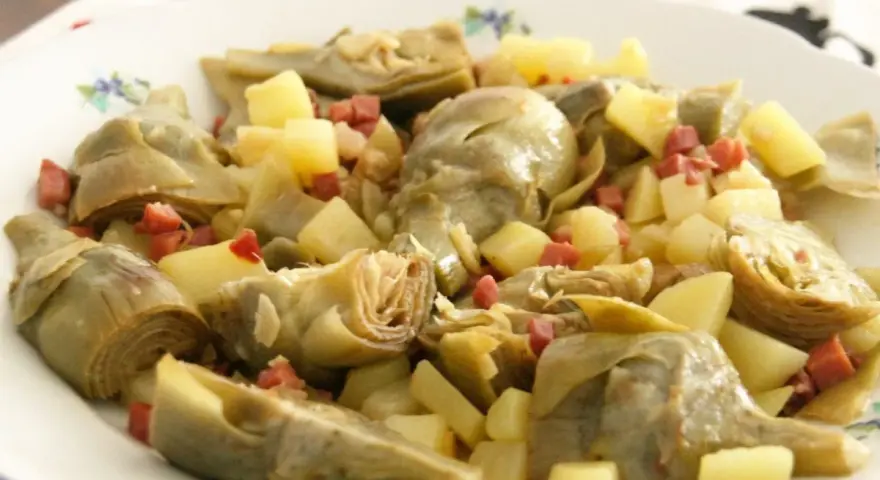 Plato de alcachofas tiernas y trocitos de jamón serrano, un clásico delicioso.