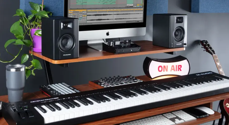 M-Audio Keystation 61, monitory studyjne, komputer z programem do produkcji muzyki, gitara i lampa "ON AIR" tworzą profesjonalne studio.