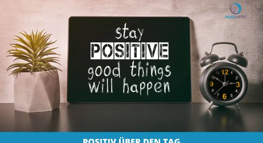 Guten Morgen Affirmationen: Ein Tablet mit der Aufschrift "stay POSITIVE good things will happen" neben einer Topfpflanze und einem Wecker.