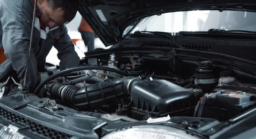 Mechanik pracuje przy silniku, przygotowując się do odpowietrzenia sprzęgła 1.9 TDI.