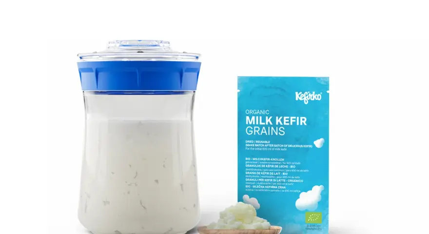 Kefirko Bio Milch Kefir Körner für gesunden Kefir. Ein Glas mit Kefir und eine Packung mit Kefir-Körnern.