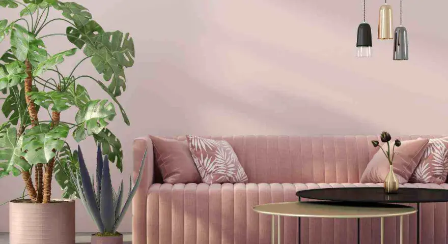 Divano rosa antico e tortora, piante verdi e lampade moderne creano un'atmosfera accogliente.