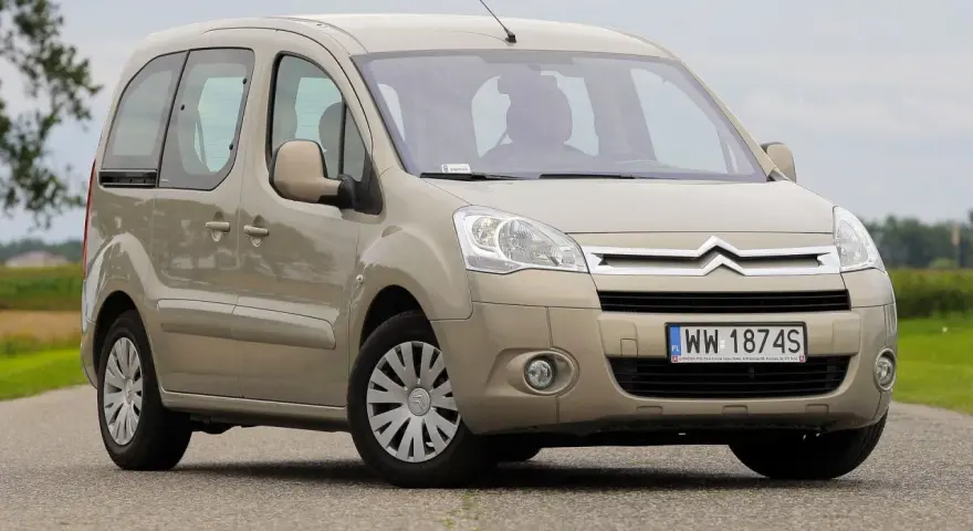 Beżowy Citroen Berlingo 1.6 HDI na drodze, z zielonym polem w tle.