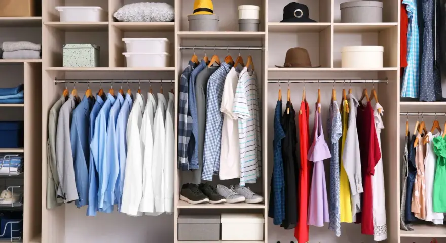 Szafa z ubraniami w stylu basic: koszule, sukienki, buty i akcesoria.
