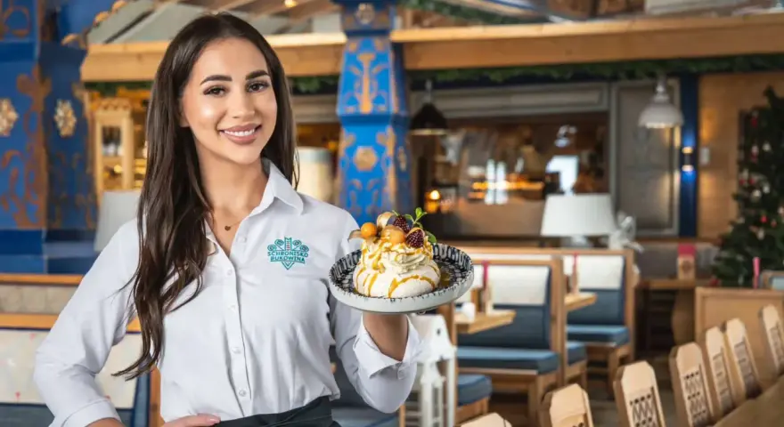 Kelnerka serwuje deser w restauracji w Bukowinie Tatrzańskiej z muzyką na żywo.