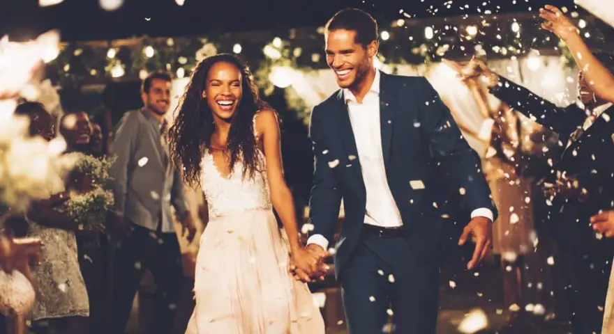 Un couple rayonnant traverse une pluie de pétales, une animation surprise mariage parfaite pour célébrer leur amour.