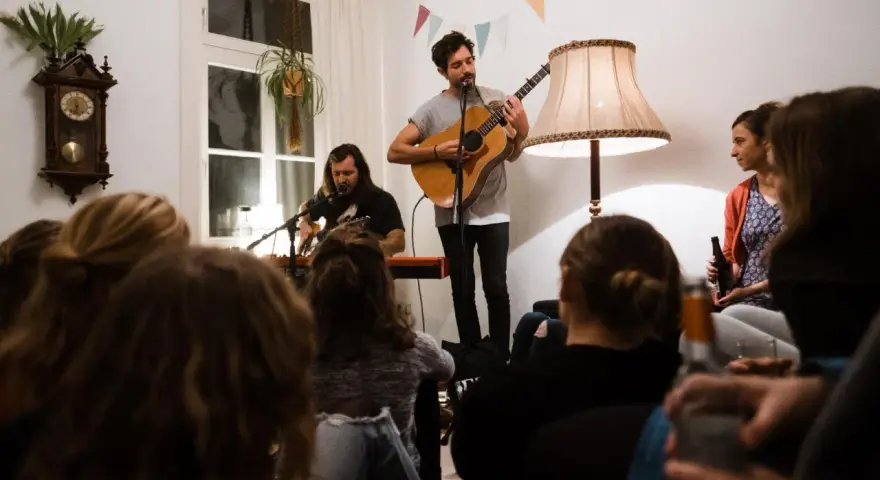 Gemütliches souly konzert berlin. Zwei Musiker spielen Gitarre und Keyboard, während das Publikum zuhört.