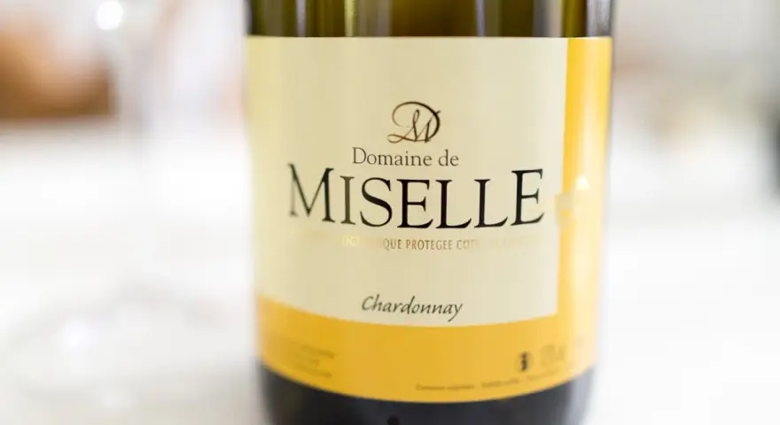 Butelka wina Domaine de Miselle, z wyraźnym napisem "Chardonnay". Idealne na letnie wieczory.