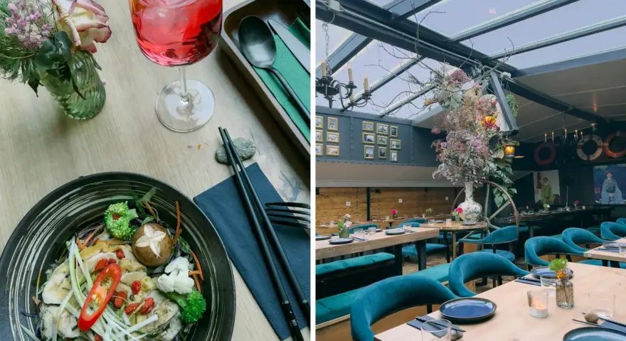 Ein Gericht mit Hühnchen und Gemüse, daneben ein Getränk. Im Hintergrund ein stilvolles Restaurant mit Spree-Blick.