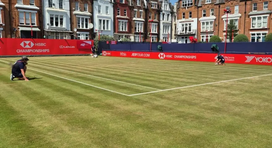 Jugadores preparan la cancha de césped para el torneo de Queen's Club.