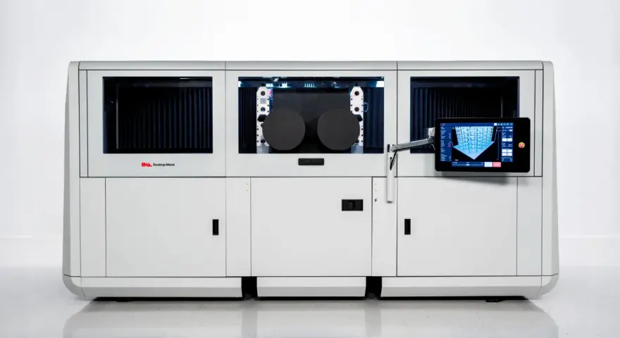 Nowoczesna maszyna do druku 3D, wykorzystująca technologię binder jetting, z panelem dotykowym prezentującym proces budowy.
