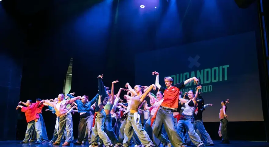 Tancerze na scenie, w ruchu, jakby tworzyli choreografię na żywo. To właśnie improwizacja co to – spontaniczność i kreatywność w tańcu.