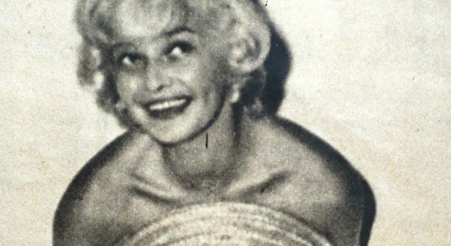 Uśmiechnięta Marilyn Monroe, ikona kina, w czarno-białym ujęciu. Jej imię zna cały świat.