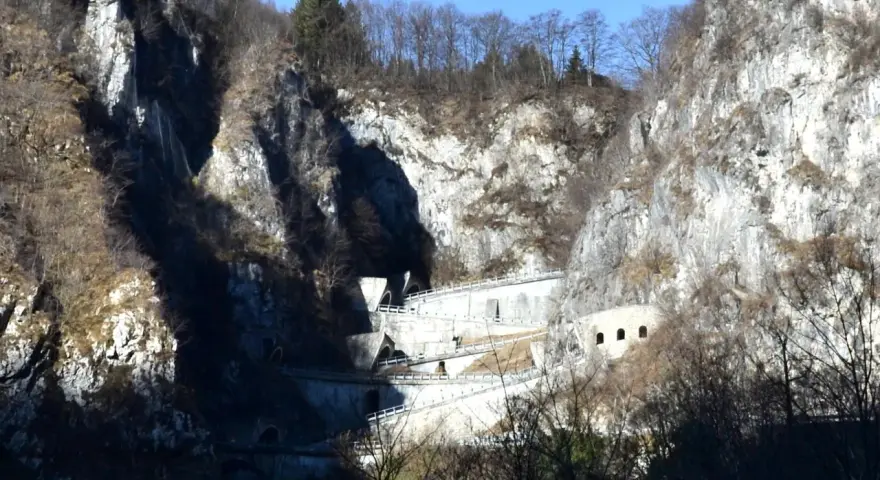 Strada a tornanti sul Passo San Boldo, con gallerie e muri di sostegno che si aggrappano alla roccia.