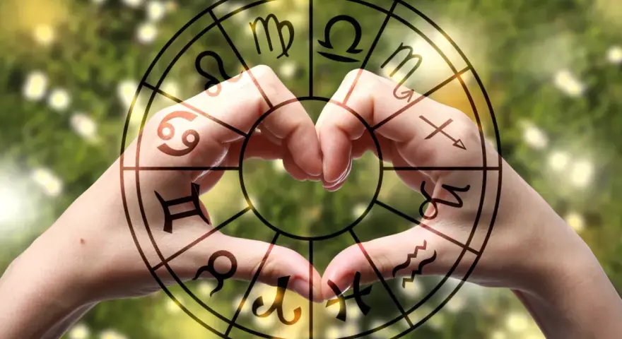 Dłonie tworzą serce w okręgu zodiaku, gdzie widnieją symbole, w tym te z najtrudniejszych znaków zodiaku.