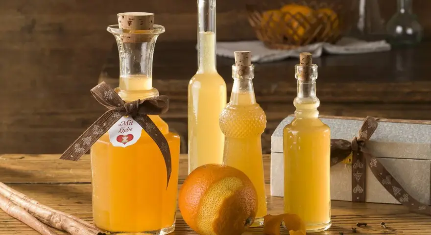 Flaschen mit selbstgemachtem Schnaps, ideal zum Schnaps selber machen mit Wodka. Orangen, Zimt und Sternanis deuten auf fruchtige Aromen hin.