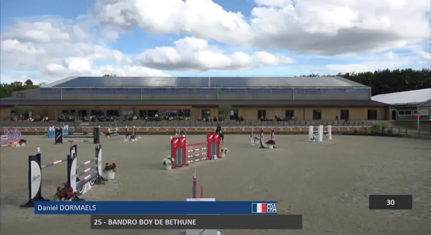 Daniel Dormaels et son cheval 25 - Bandro Boy de Bethune s'élancent sur la piste d'obstacles sous un ciel nuageux.