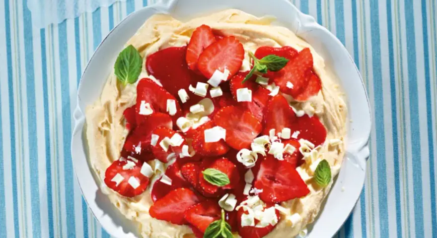 Eine köstliche Eiscreme-Pizza mit frischen Erdbeeren, weißer Schokolade und Minze.