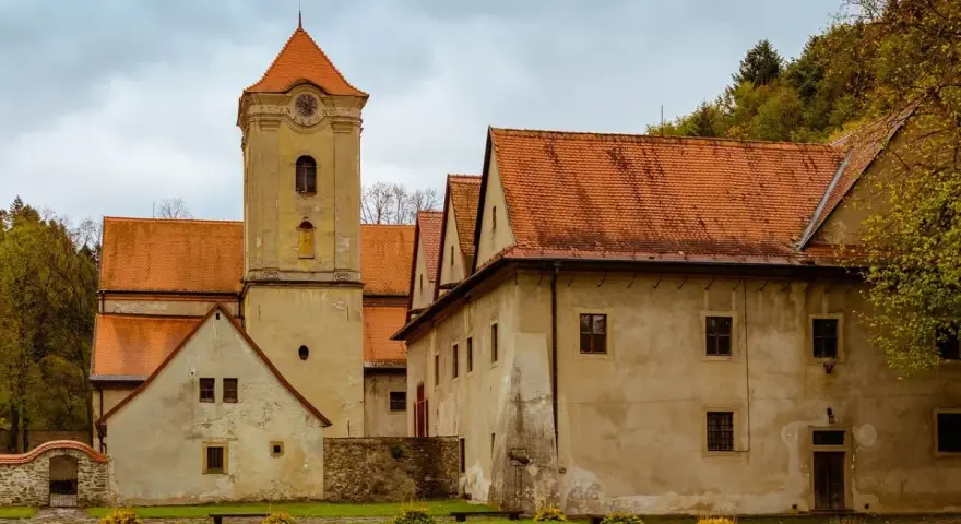 Czerwony Klasztor w Pieninach z wieżą zegarową i pomarańczowymi dachami.