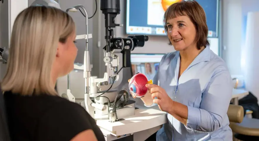 Augenarzt erklärt Modellauge. Mögliche Behandlung: Augen lasern. Krankschreibung wird besprochen.