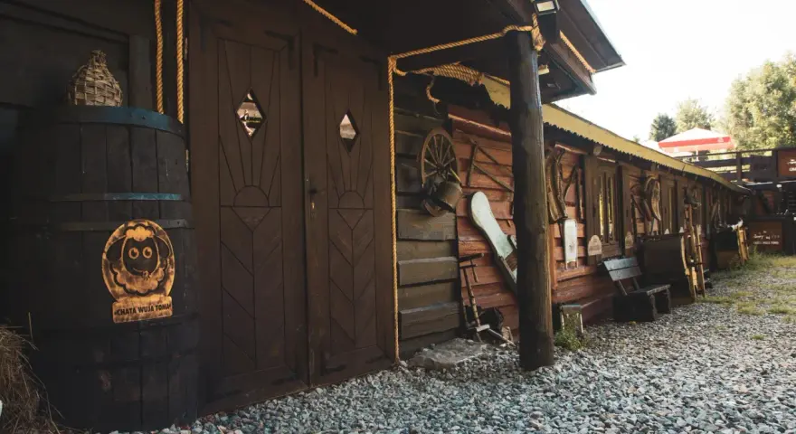 Drewniana chata wuja Toma z beczką i ozdobami.