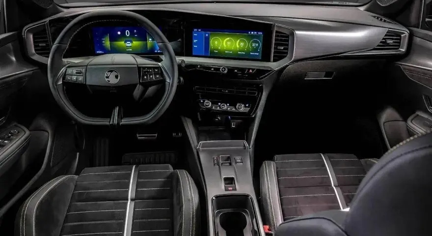 Wnętrze nowoczesnego Vauxhalla z dwoma ekranami, sportowymi fotelami i eleganckimi detalami.