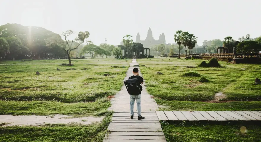 Chłopiec z plecakiem idzie ścieżką do Angkor Wat, jednego z cudów największego kontynentu na ziemi.