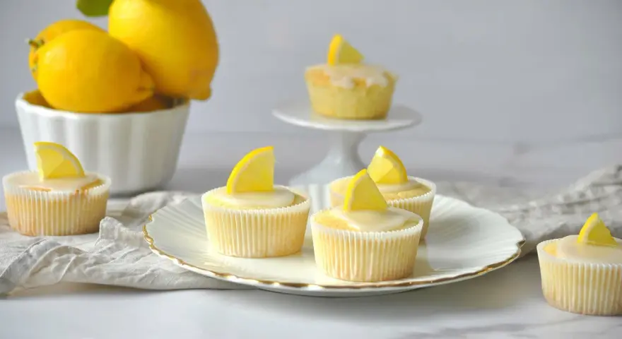 Erfrischende Zitronenmuffins mit Zuckerguss und Zitronenspalten, inspiriert von einem einfachen zitronenmuffins rezept.