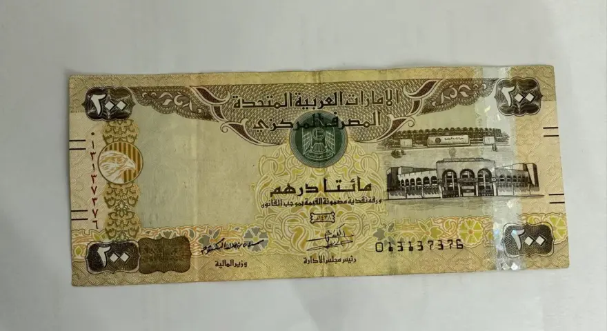Banknot 200 dirhamów Zjednoczonych Emiratów Arabskich. AED jaka to waluta, widzimy orła i budynek.