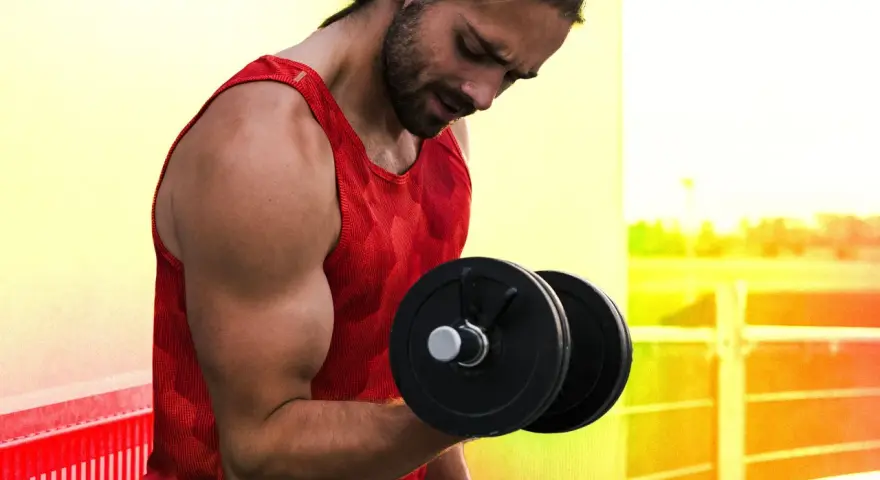 Homme musclé faisant un exercice pour muscler les bras avec un haltère.