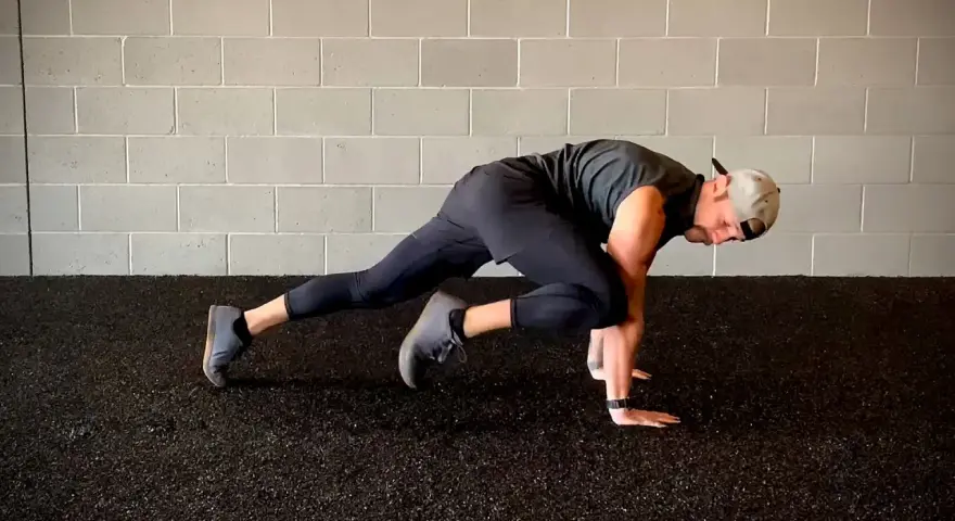Un homme fait des mountain climbers pour son renforcement musculaire à la maison.