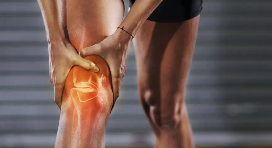 Person hält schmerzendes, dickes Knie. Was tun bei Knieproblemen? Rote Hitze zeigt Entzündung.