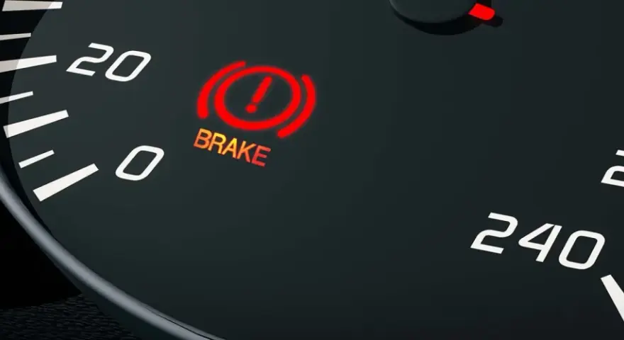 The car's dashboard shows the red brake light on, indicating a potential issue.