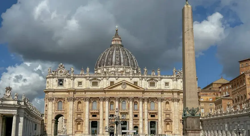 St. Peter's Basilica, one of the most beautiful churches in Rome, stands majestically with its dome and an ancient obelisk in the foreground.