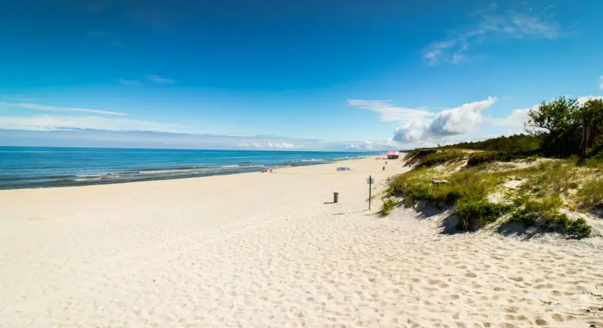 Piękna, piaszczysta plaża na Mierzei Wiślanej. Błękitne niebo i spokojne morze zapraszają do wypoczynku.