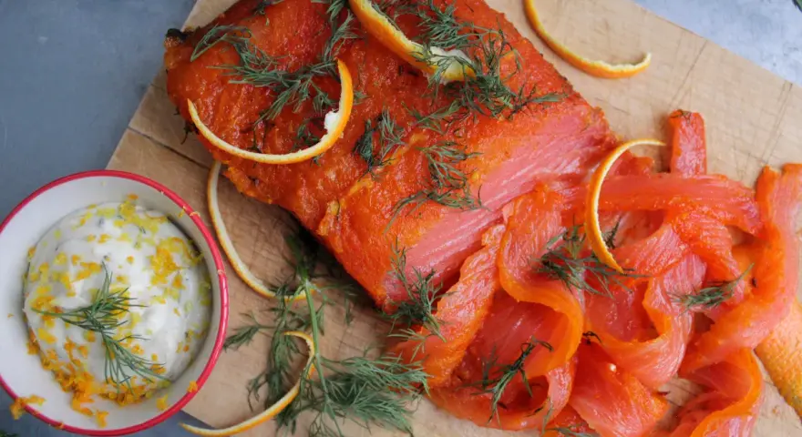 Rökt lax med apelsinzest och dill, serverad med en krämig sås till lax. Perfekt för en festlig måltid.