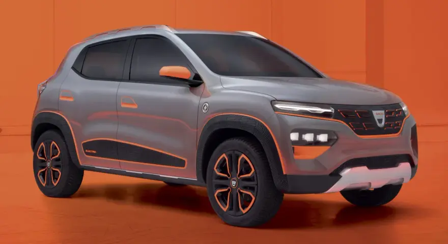 Szary samochód Dacia Spring z pomarańczowymi akcentami na tle pomarańczowym.