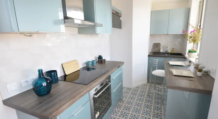 Cocina moderna y luminosa con armarios celestes y suelo hidráulico. Una opción económica para renovar cocina con poco dinero.