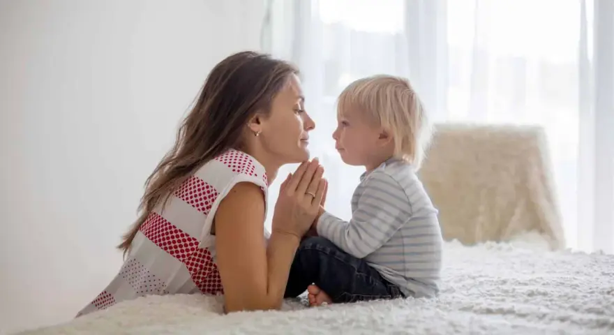 Mutter und Sohn beten gemeinsam. Ein schönes Beispiel für christliche Erziehung, das Vertrauen und Liebe lehrt.